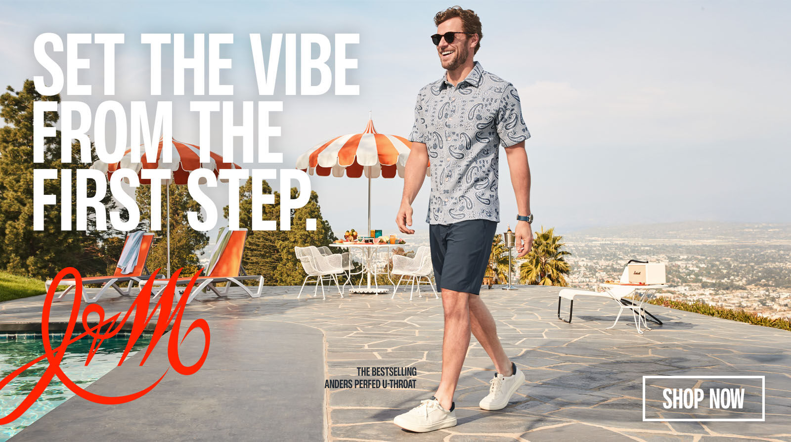 Man dressed in Johnston & Murphy blue patterned polo with navy shorts on, walking on a patio with a red J&M logo and words that read "set the vibe from the step" with a shop now button on the left of the guy.